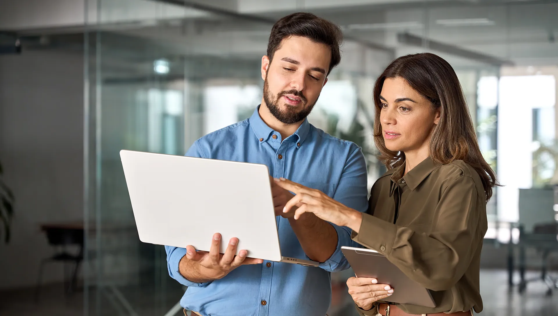 Two people reviewing training compliance reports